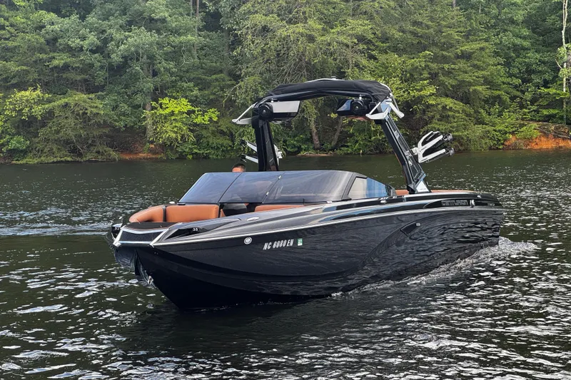 Slide: The Image of 2020 Centurion Ri257 boat cruising on a scenic lake with lush green forest backdrop. - 6