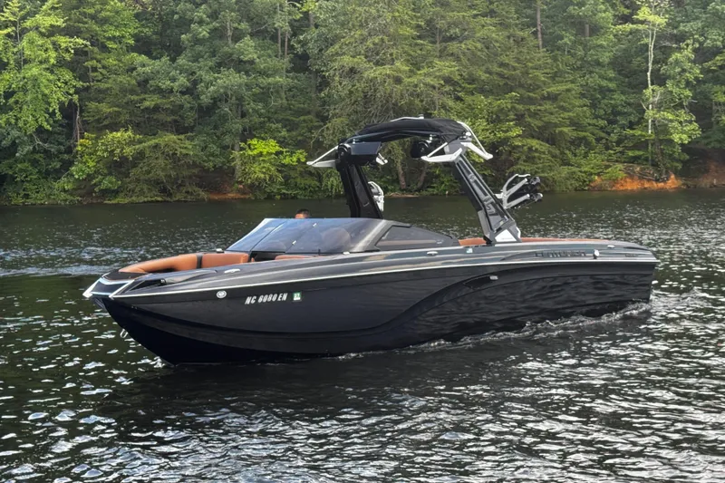 Slide: The Image of 2020 Centurion Ri257 boat cruising on a lake with lush green forest backdrop. - 7