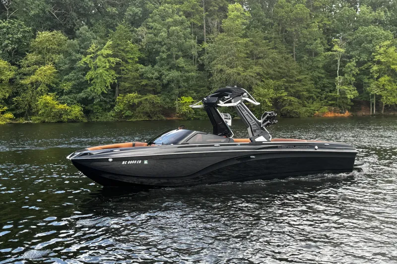 Slide: The Image of 2020 Centurion Ri257 boat cruising on a serene lake with lush green forest backdrop. - 8