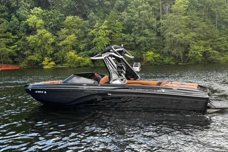 Slide: The Image of 2020 Centurion Ri257 boat on a lake with lush green forest background. - 9