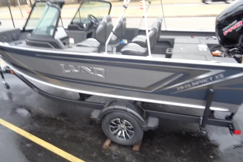 Slide: The Image of 2025 Lund 1875 Impact XS Sport boat on trailer, parked on wet pavement. - 4