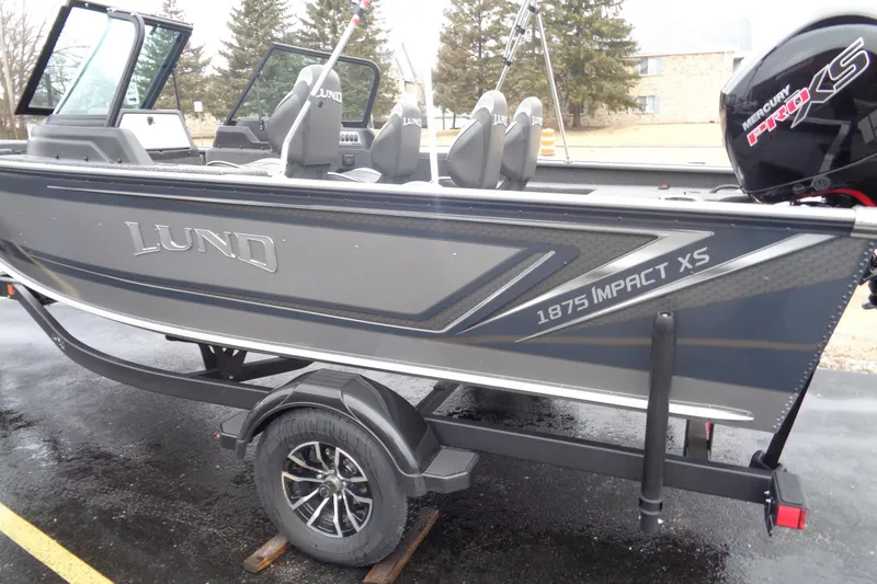 Slide: The Image of 2025 Lund 1875 Impact XS Sport boat on trailer, featuring sleek design and Mercury Pro XS engine. - 8
