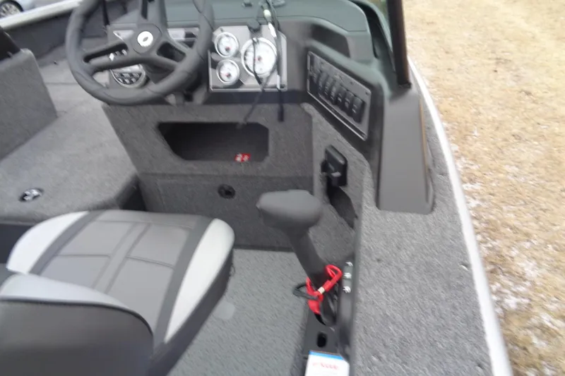 Slide: The Image of 2025 Lund 1875 Impact XS Sport boat interior with steering wheel and control panel. - 9