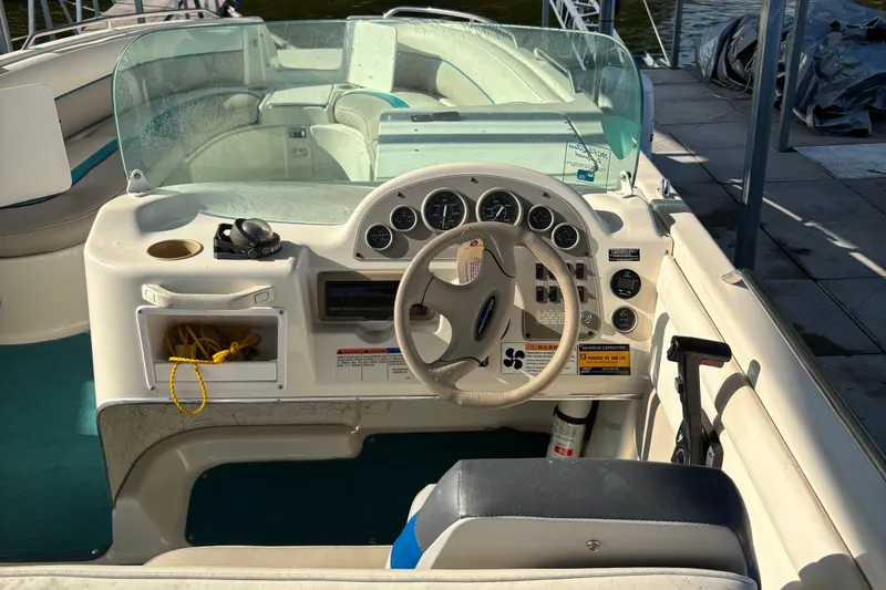 Slide: The Image of 1996 Bayliner 2659 Rendezvous boat cockpit with steering wheel and dashboard controls. - 2