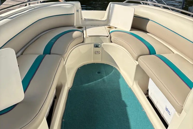 Slide: The Image of 1996 Bayliner 2659 Rendezvous boat interior with cushioned seating and teal carpet. - 3
