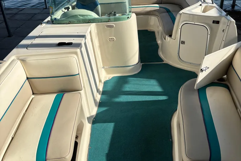 Slide: The Image of 1996 Bayliner 2659 Rendezvous boat interior with teal carpet and cushioned seating. - 4