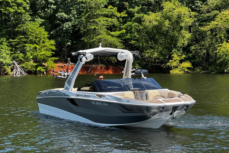 Slide: The Image of 2023 Centurion Fi25 boat cruising on a scenic lake with lush green trees. - 3