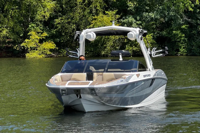 Slide: The Image of 2023 Centurion Fi25 boat cruising on a serene lake surrounded by lush greenery. - 6