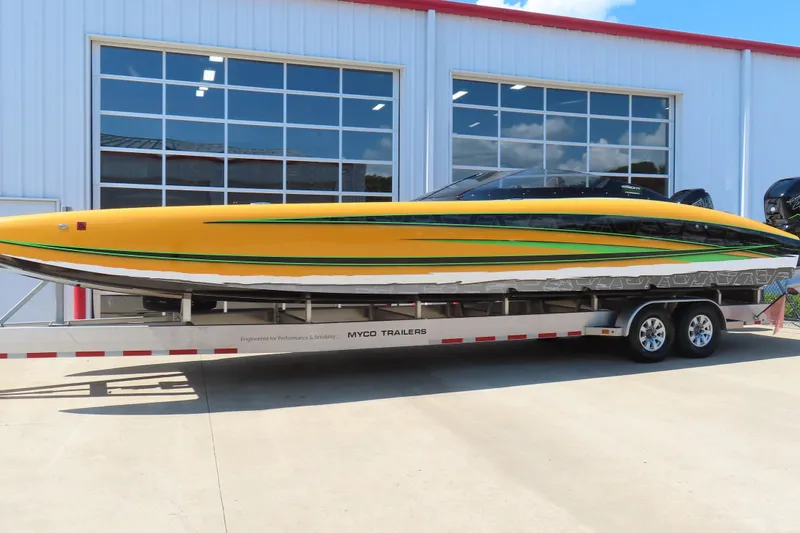 Slide: The Image of 2019 Wright Performance WP 360 boat on trailer, yellow with green accents, parked outside a building. - 22