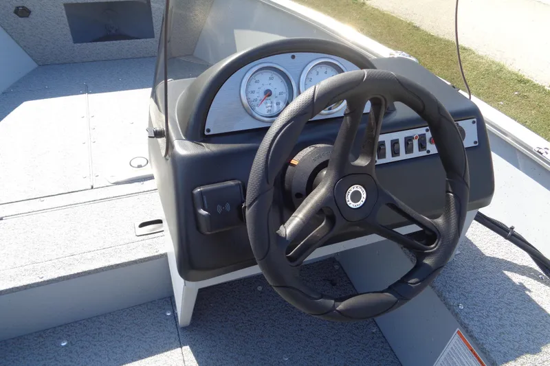 Slide: The Image of 2026 Lund 1600 Fury SS boat dashboard with steering wheel and gauges. - 11