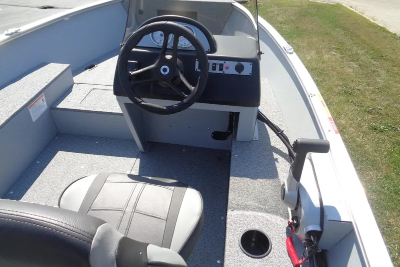 Slide: The Image of 2026 Lund 1600 Fury SS boat interior with steering wheel and control panel. - 13