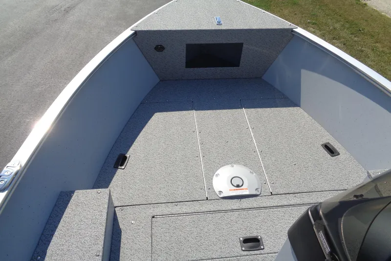 Slide: The Image of 2026 Lund 1600 Fury SS boat interior with gray carpeted deck and storage compartments. - 15