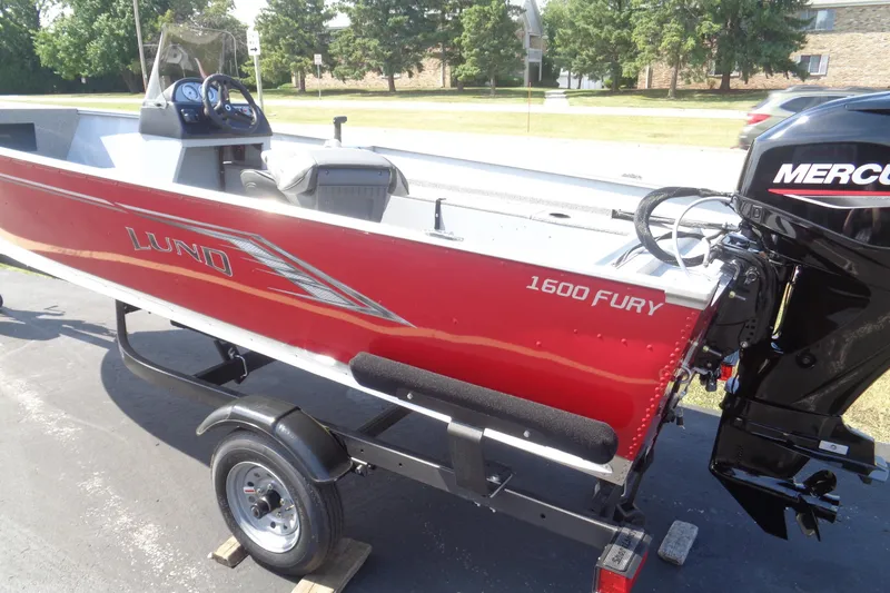 Slide: The Image of 2026 Lund 1600 Fury SS boat with Mercury engine on trailer, parked outdoors. - 4