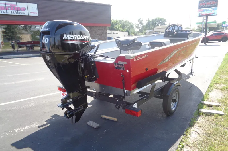 Slide: The Image of 2026 Lund 1600 Fury SS boat with Mercury 40 engine, parked outdoors. - 6