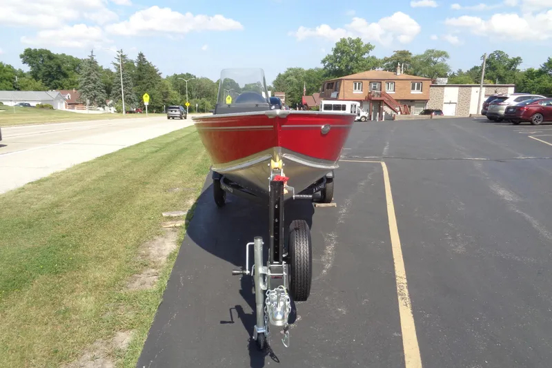 Slide: The Image of 2026 Lund 1600 Fury SS boat on trailer, parked on asphalt near grassy area. - 9