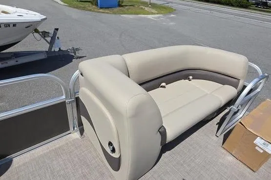 Slide: The Image of 2025 Sun Tracker PB 18 DLX pontoon boat with beige seating on a sunny day. - 12