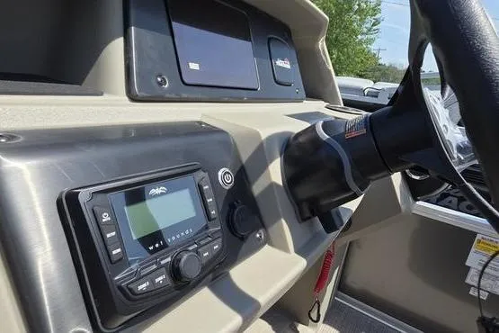 Slide: The Image of 2025 Sun Tracker PB 18 DLX boat dashboard with steering wheel and control panel. - 6