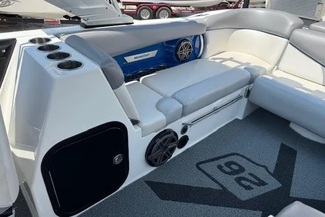 Slide: The Image of 2016 MasterCraft X26 boat interior with seating, speakers, and cup holders. - 7