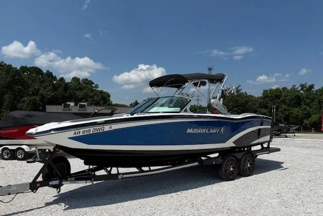 The Image of 2016 MasterCraft X26 boat on trailer, blue and white, parked outdoors. - 9