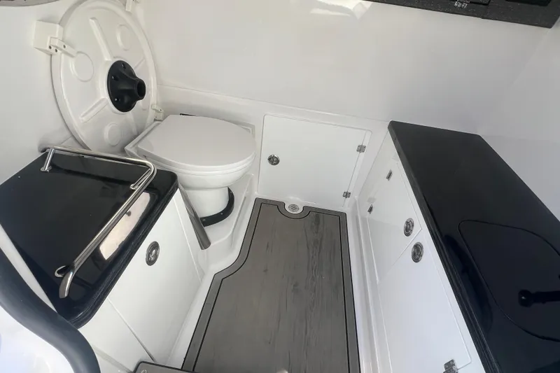 Slide: The Image of 2026 Monterey Elite 27 OB boat interior with toilet and storage cabinets. - 11