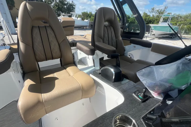 Slide: The Image of Luxury seating in 2026 Monterey Elite 27 OB boat cockpit, featuring modern design and controls. - 16