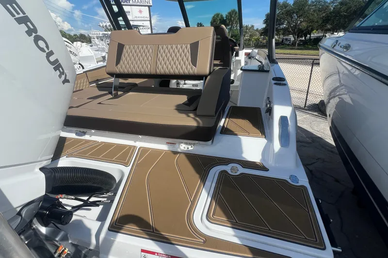 Slide: The Image of 2026 Monterey Elite 27 OB boat with brown seating and deck, docked outdoors. - 19