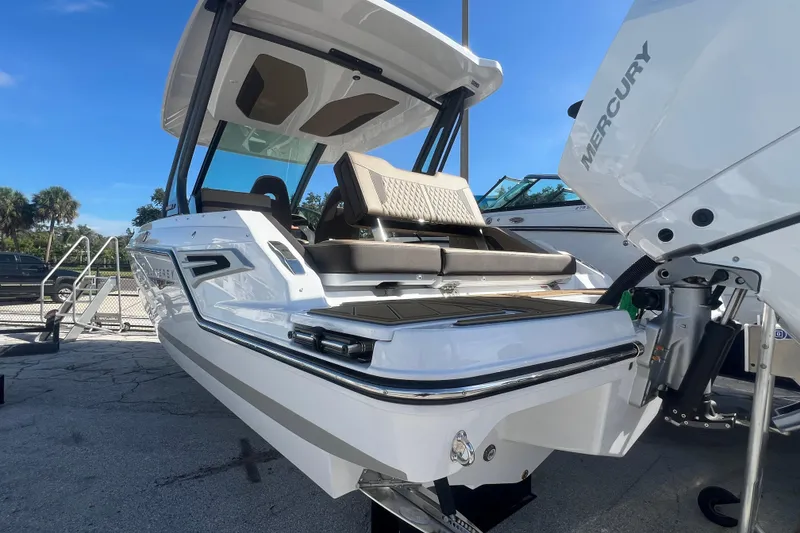 Slide: The Image of 2026 Monterey Elite 27 OB boat with Mercury engine, docked under clear blue sky. - 21