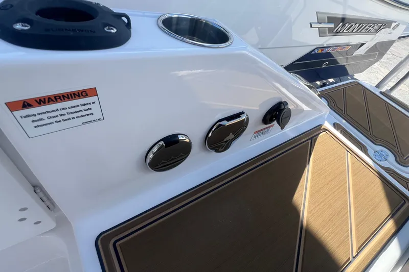 Slide: The Image of 2026 Monterey Elite 27 OB boat deck with warning label and controls. - 7
