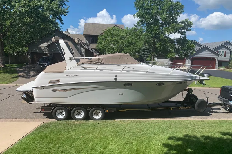 The Image of 2002 Crownline 290 CR boat on trailer in suburban neighborhood. - 0