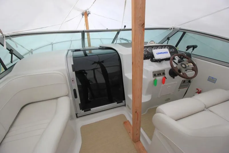 Slide: The Image of 2002 Crownline 290 CR boat interior with steering wheel and seating area. - 13