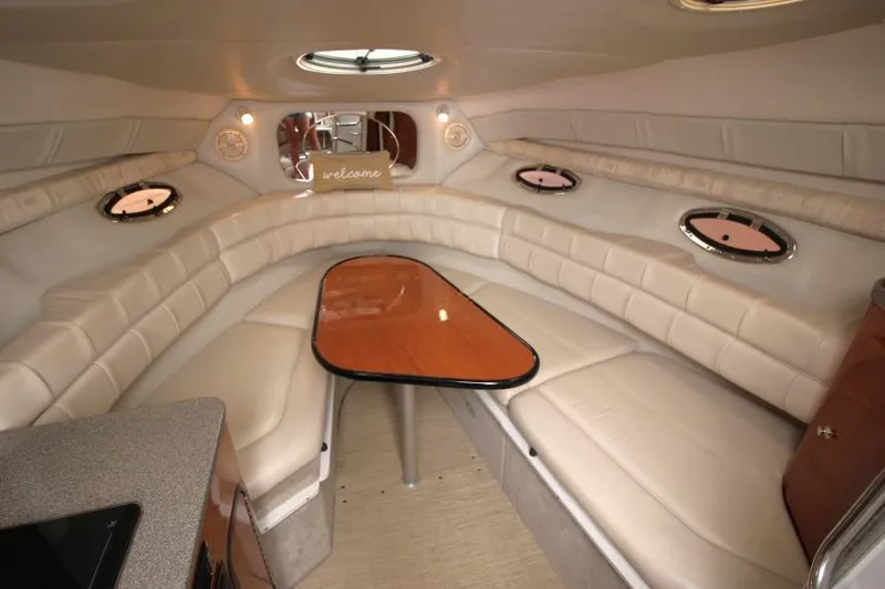 Slide: The Image of Luxurious interior of 2002 Crownline 290 CR boat with plush seating and wooden table. - 14