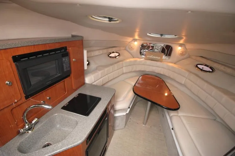 Slide: The Image of Interior of 2002 Crownline 290 CR boat with kitchenette and seating area. - 15
