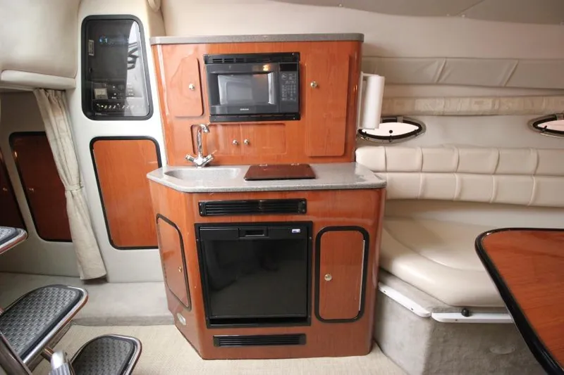 Slide: The Image of 2002 Crownline 290 CR boat interior with kitchenette and seating area. - 16