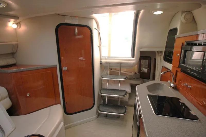 Slide: The Image of Interior of 2002 Crownline 290 CR boat with kitchenette and stairs. - 18