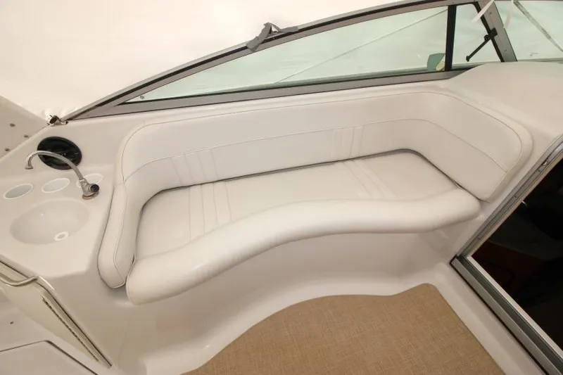 Slide: The Image of 2002 Crownline 290 CR boat interior with white seating and sink area. - 5