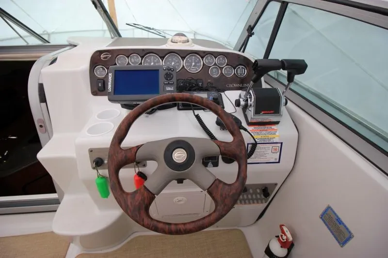 Slide: The Image of 2002 Crownline 290 CR boat dashboard with steering wheel and navigation controls. - 8