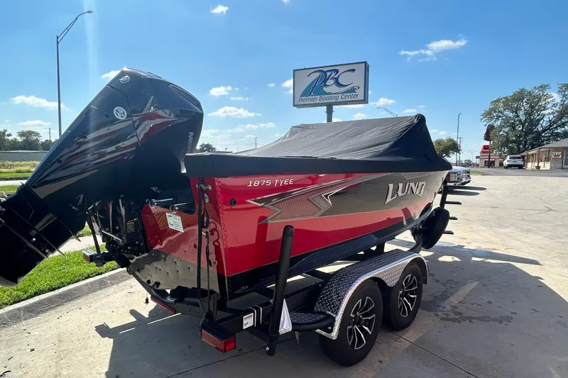 Slide: The Image of 2026 Lund 1875 Tyee boat on trailer at Premier Boating Center, sunny day. - 7