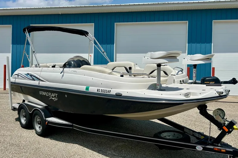 Slide: The Image of 2009 Starcraft Star Step boat on trailer, parked near blue building. - 1