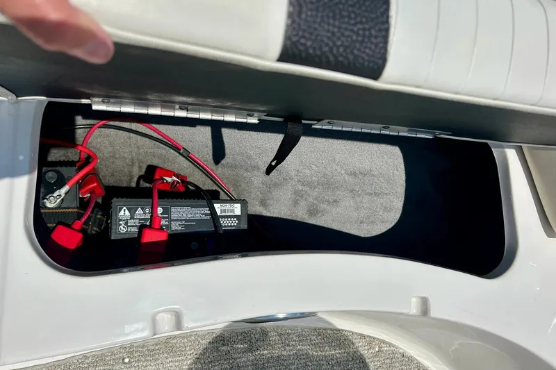 Slide: The Image of 2009 Starcraft Star Step boat battery compartment with red cables and secure storage. - 10