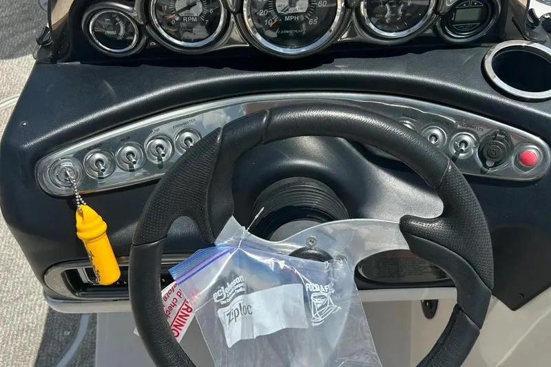 Slide: The Image of 2009 Starcraft Star Step boat dashboard with steering wheel and control panel. - 15