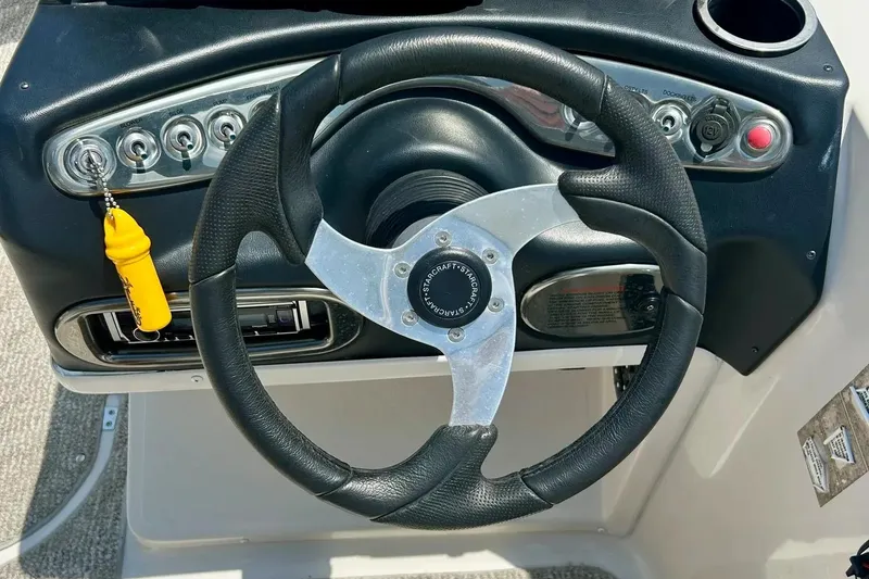 Slide: The Image of Steering wheel of 2009 Starcraft Star Step boat with control panel and keychain. - 19