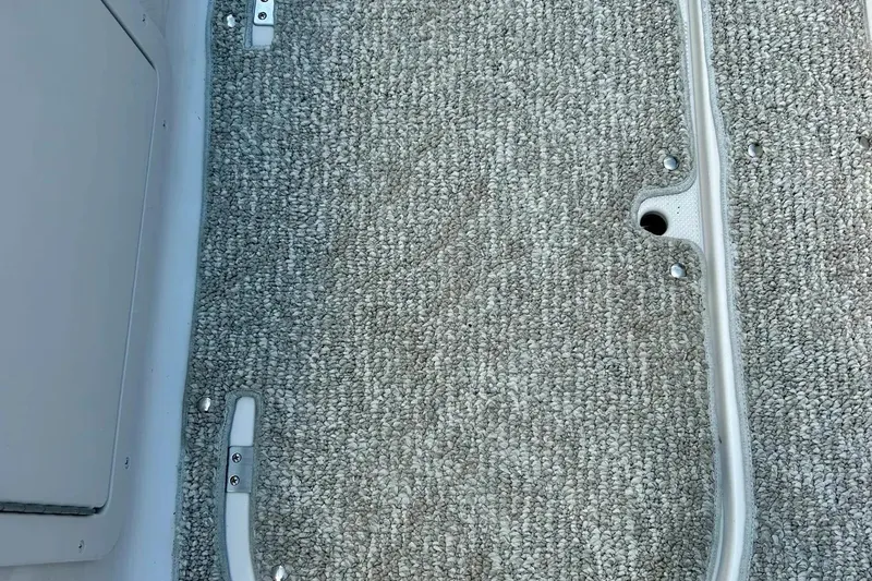 Slide: The Image of 2009 Starcraft Star Step boat carpet with metal fixtures and textured surface. - 24