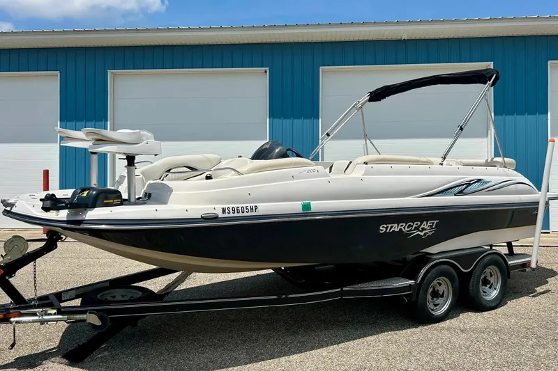 Slide: The Image of 2009 Starcraft Star Step boat on trailer, parked near blue building. - 37