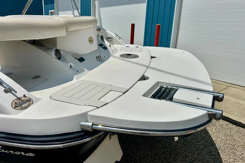 Slide: The Image of 2009 Starcraft Star Step boat with swim platform and ladder, docked near blue building. - 38