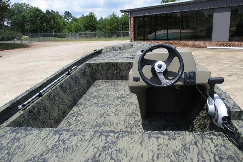 Slide: The Image of 2026 Tracker GRIZZLY® 1648 SC boat with camouflage interior and steering console. - 3