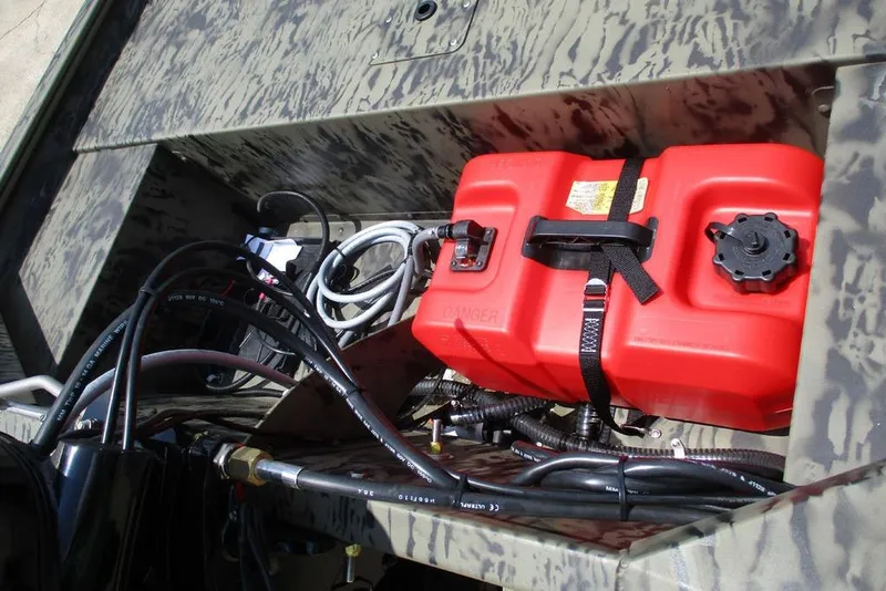 Slide: The Image of 2026 Tracker GRIZZLY® 1648 SC boat storage with red fuel tank and cables. - 6