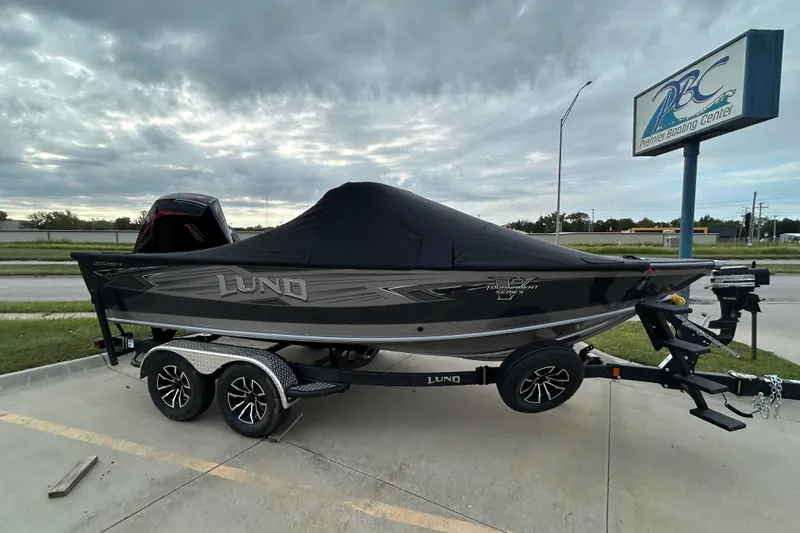 Slide: The Image of 2026 Lund 1875 Pro-V boat on trailer, covered, parked at Premier Boating Center. - 0
