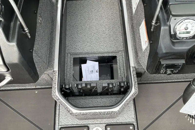 Slide: The Image of 2026 Lund 1875 Pro-V boat interior with storage compartment and control panel. - 13