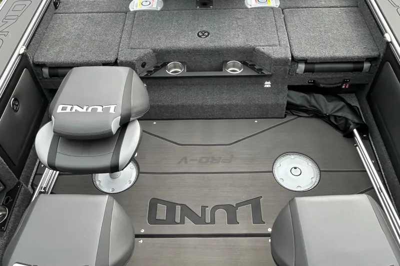 Slide: The Image of 2026 Lund 1875 Pro-V boat interior with seating and storage compartments. - 14