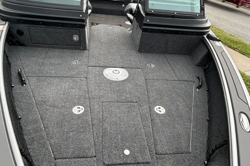 Slide: The Image of 2026 Lund 1875 Pro-V boat interior with carpeted deck and storage compartments. - 18